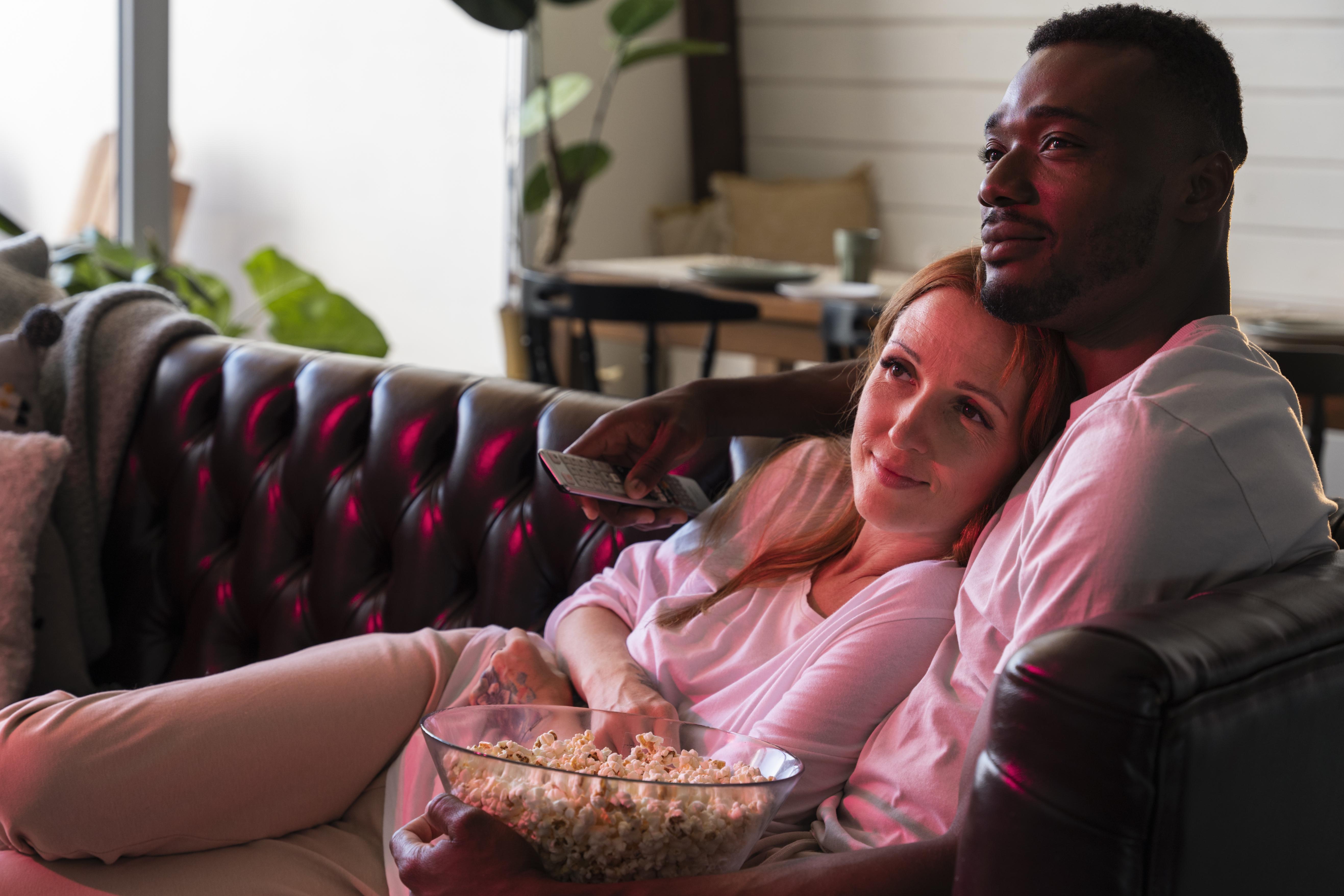 A couple watching a movie on a sofa